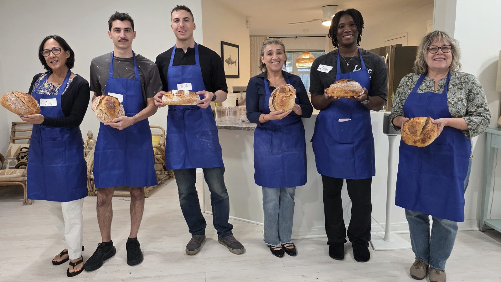 Bread Together class students holding their sourdough loaves